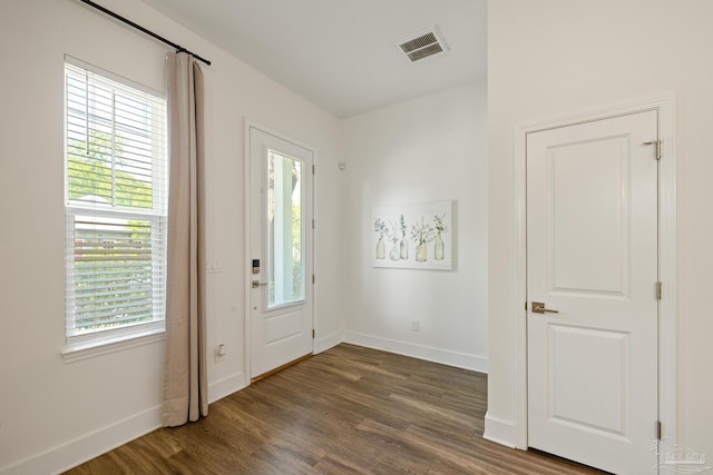 foyer entrance featuring dark wood-type flooring and baseboards