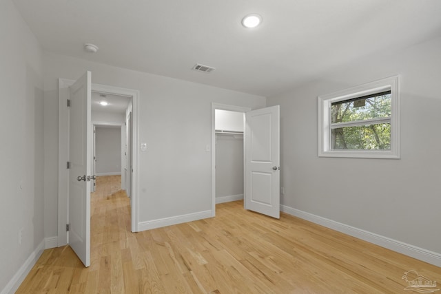 unfurnished bedroom with baseboards, visible vents, a closet, and light wood-type flooring