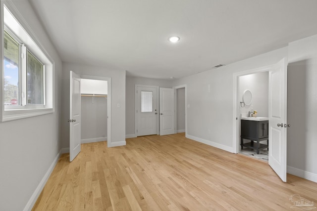 unfurnished bedroom featuring light wood-style floors, visible vents, and baseboards