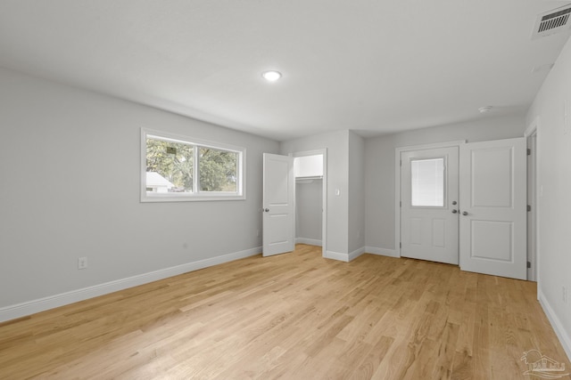 unfurnished bedroom featuring baseboards, visible vents, and light wood finished floors