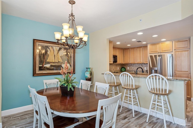 dining space featuring sink and a notable chandelier