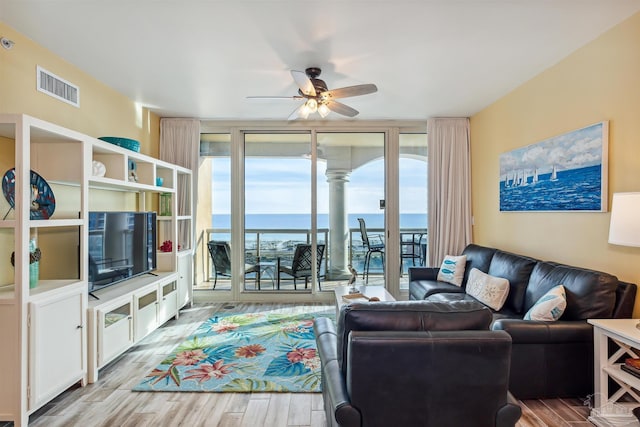 living room featuring floor to ceiling windows, ceiling fan, and light hardwood / wood-style floors