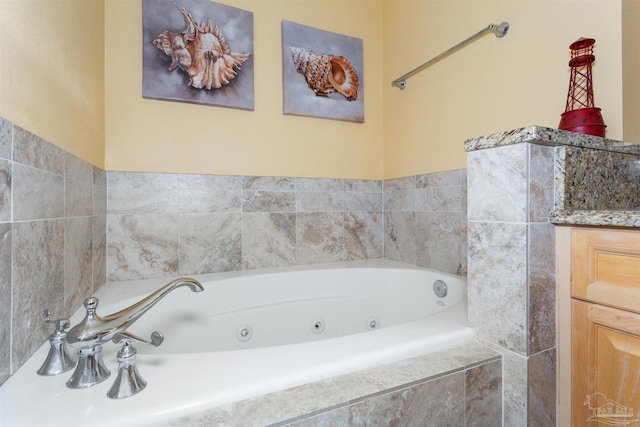 bathroom featuring vanity and a relaxing tiled tub