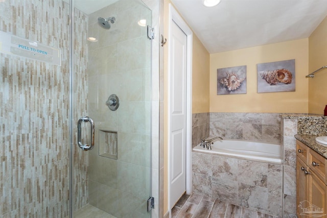 bathroom featuring vanity, hardwood / wood-style flooring, and separate shower and tub