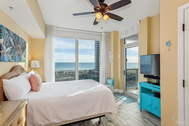 bedroom with multiple windows, access to exterior, ceiling fan, and light wood-type flooring