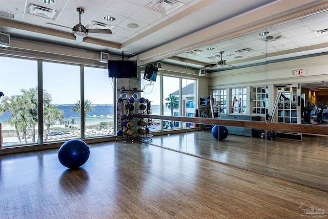 gym with hardwood / wood-style floors, a drop ceiling, and ceiling fan