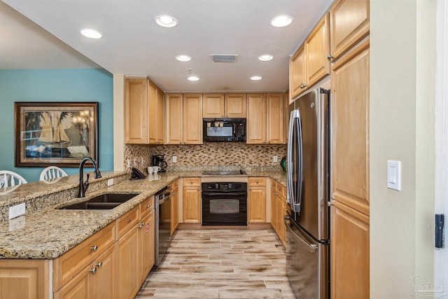 kitchen with light brown cabinetry, tasteful backsplash, sink, light stone counters, and black appliances