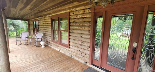 entrance to property with a porch and french doors