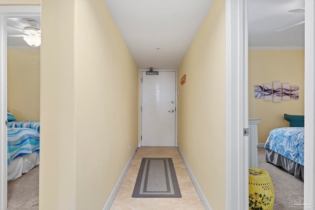 corridor featuring light tile patterned floors and ornamental molding