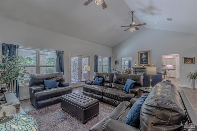 living area featuring high vaulted ceiling, a ceiling fan, wood finished floors, and visible vents