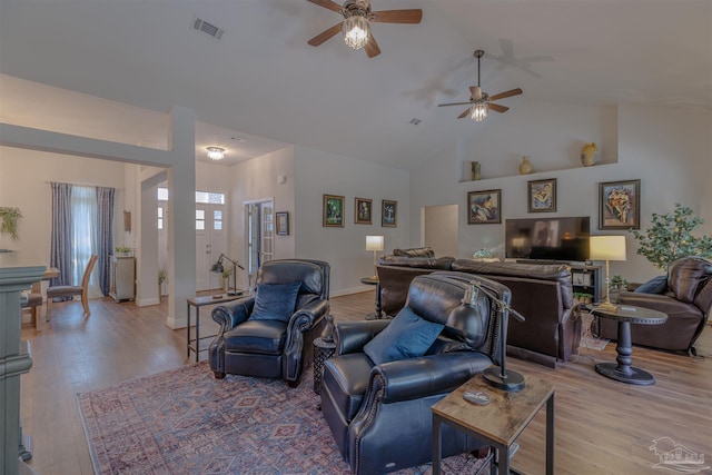 living room with visible vents, baseboards, ceiling fan, high vaulted ceiling, and light wood-type flooring