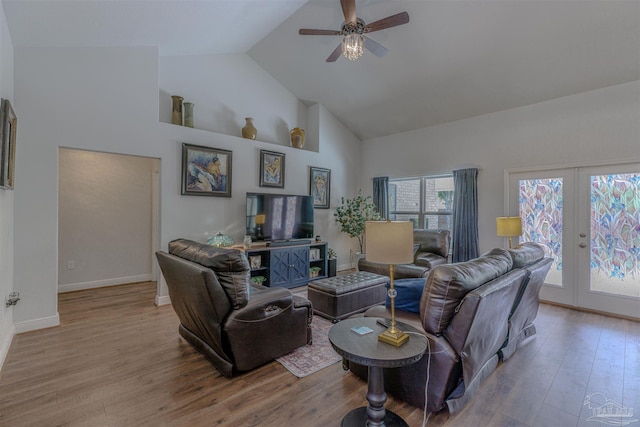 living area with wood finished floors, baseboards, ceiling fan, high vaulted ceiling, and french doors