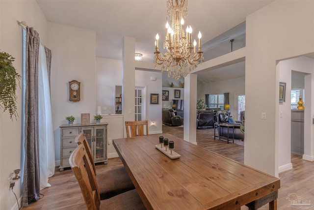 dining area with baseboards, wood finished floors, and a chandelier