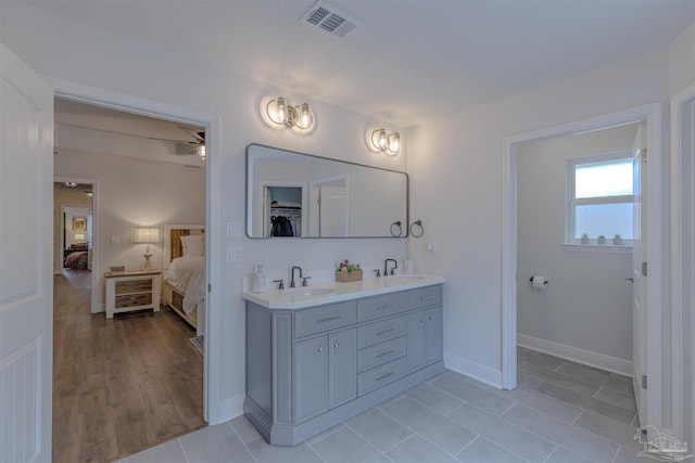 ensuite bathroom featuring a ceiling fan, visible vents, a sink, and ensuite bath