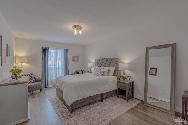 bedroom featuring baseboards and wood finished floors
