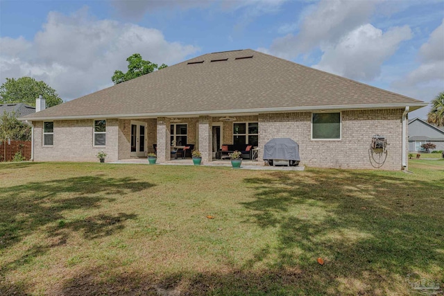 rear view of property featuring a yard, a ceiling fan, a patio area, and roof with shingles
