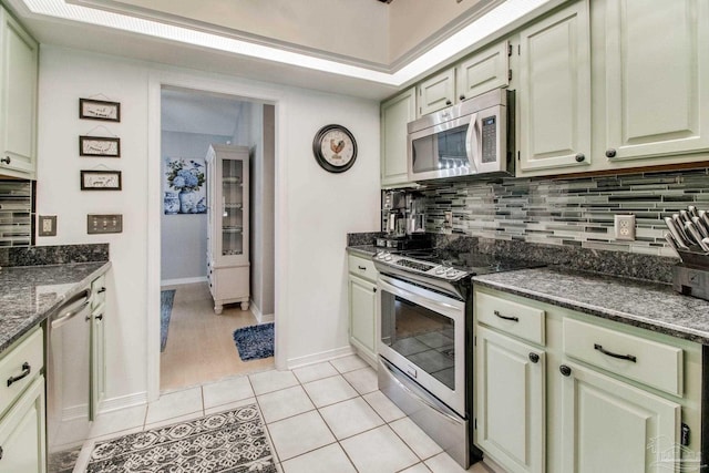 905 Shadow Ridge Dr, Pensacola, FL 32514 - kitchen featuring appliances with stainless steel finishes, backsplash, light tile patterned floors, dark stone counters, and baseboards