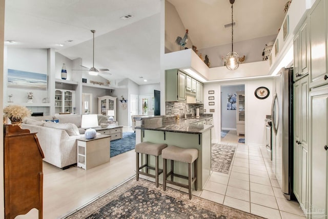 905 Shadow Ridge Dr, Pensacola, FL 32514 - kitchen with high vaulted ceiling, freestanding refrigerator, a breakfast bar, ceiling fan, and a peninsula