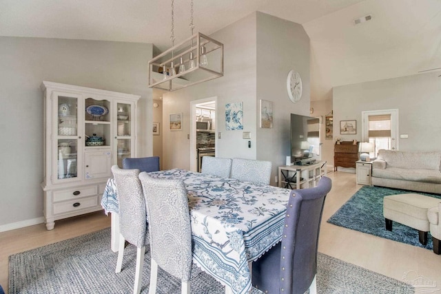 905 Shadow Ridge Dr, Pensacola, FL 32514 - dining area featuring a chandelier, high vaulted ceiling, light wood-style floors, baseboards, and healthy amount of natural light