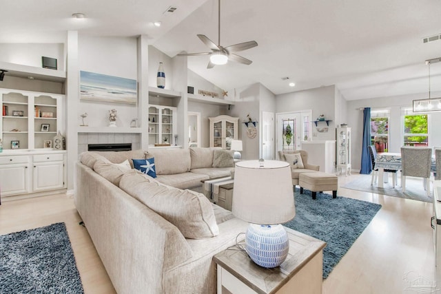 905 Shadow Ridge Dr, Pensacola, FL 32514 - living area featuring light wood-style flooring, a ceiling fan, healthy amount of natural light, a tile fireplace, and high vaulted ceiling