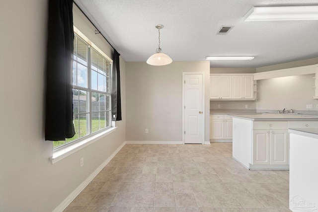 1978 Coral Reef Rd, Pensacola, FL 32506 - kitchen featuring open shelves, healthy amount of natural light, white cabinets, light countertops, and a textured ceiling