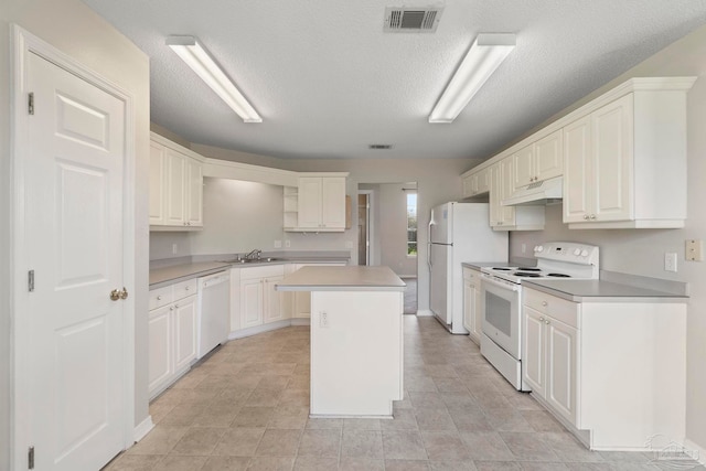 1978 Coral Reef Rd, Pensacola, FL 32506 - kitchen featuring white appliances, under cabinet range hood, a sink, a kitchen island, and light countertops