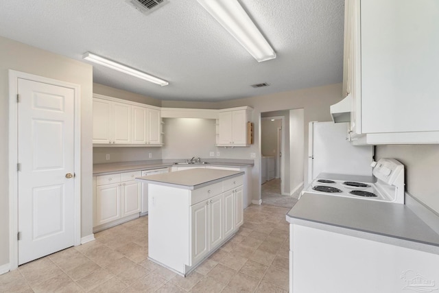 1978 Coral Reef Rd, Pensacola, FL 32506 - kitchen with white appliances, a sink, white cabinets, a textured ceiling, and a center island