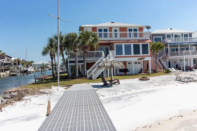 exterior space featuring a balcony, a water view, and stairway
