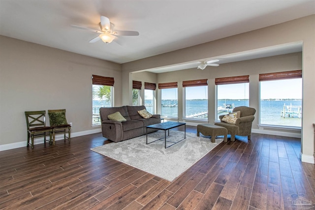living room featuring a ceiling fan, baseboards, and dark wood-style flooring