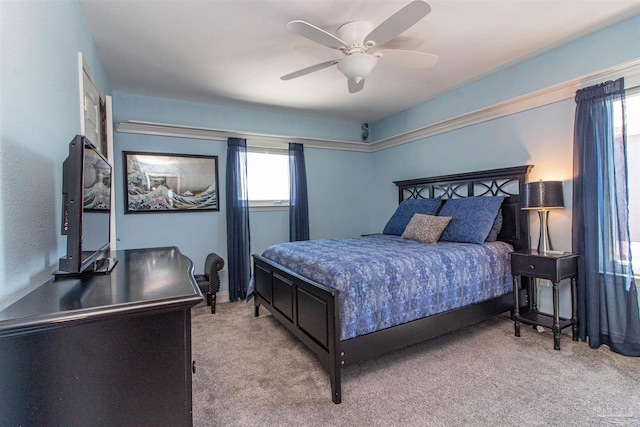 bedroom with multiple windows, ceiling fan, and light colored carpet