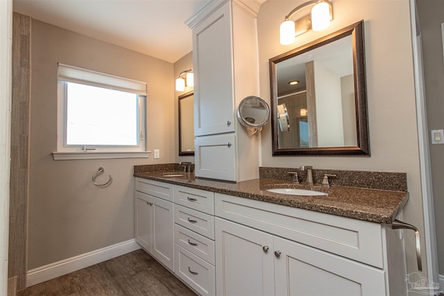 bathroom with hardwood / wood-style flooring and double vanity