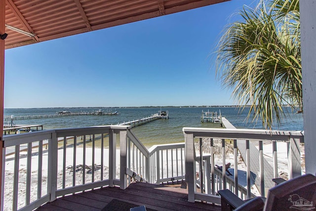 wooden deck with a dock, boat lift, and a water view