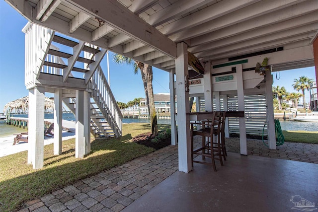 view of patio / terrace featuring a water view and stairs