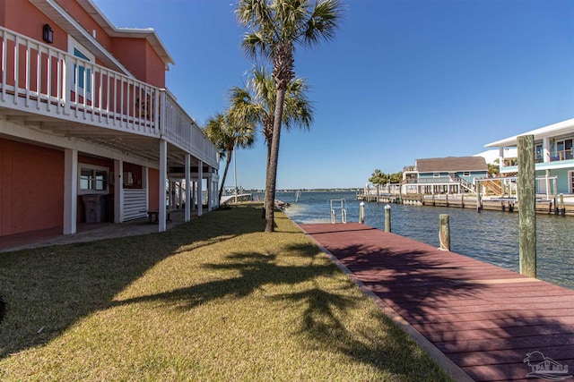 view of dock with a water view and a yard