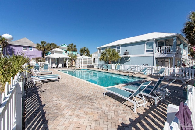 pool with a gazebo, a patio area, and fence