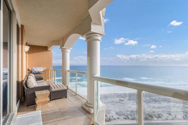 balcony featuring a water view and a beach view