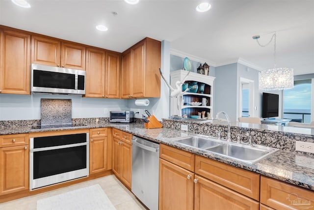 kitchen featuring dark stone countertops, sink, ornamental molding, and stainless steel appliances