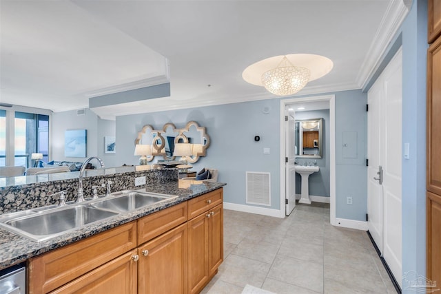 kitchen with sink, crown molding, dark stone counters, and dishwasher