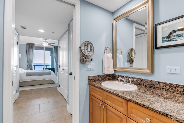 bathroom featuring vanity, tile patterned floors, ceiling fan, and a water view