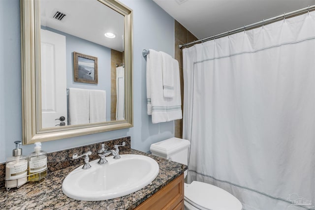 bathroom with vanity, walk in shower, and toilet