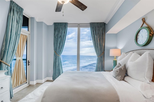 bedroom with access to outside, ceiling fan, and a water view