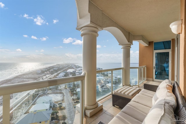 balcony featuring a view of the beach and a water view