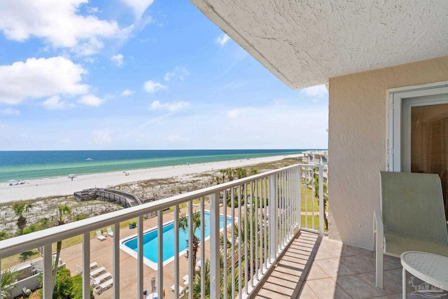 balcony featuring a view of the beach and a water view