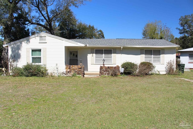 view of front of house with roof with shingles and a front yard