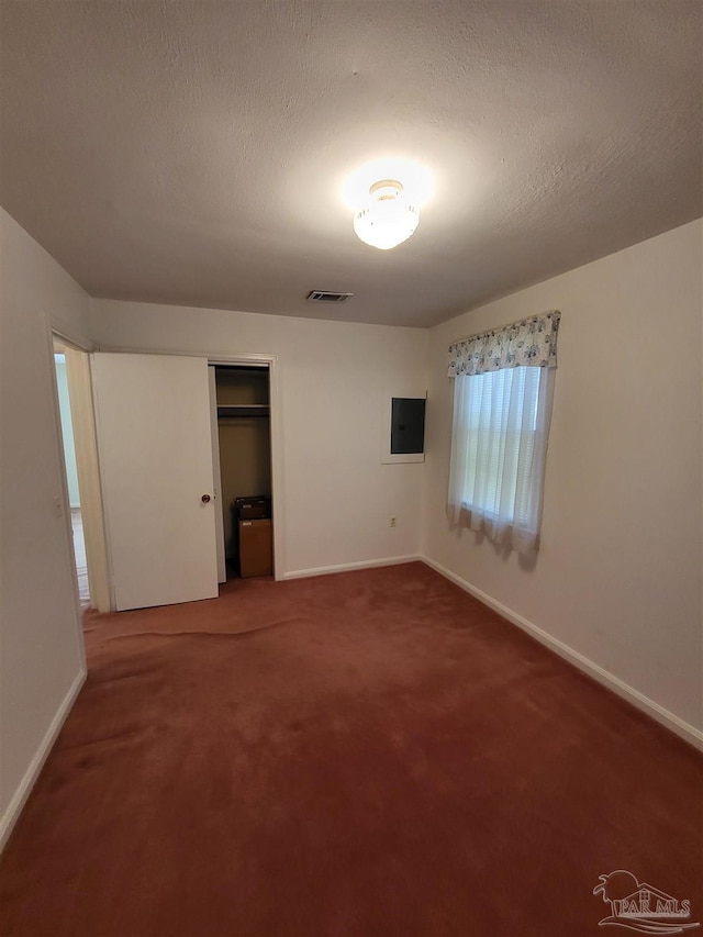 unfurnished bedroom featuring visible vents, baseboards, carpet floors, a closet, and a textured ceiling