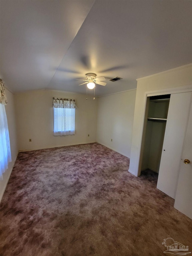 unfurnished bedroom with visible vents, carpet, crown molding, lofted ceiling, and ceiling fan