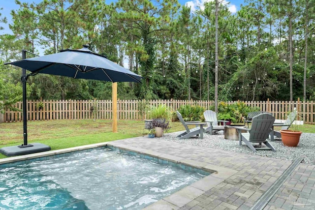 view of swimming pool featuring an outdoor fire pit, a patio, and a yard