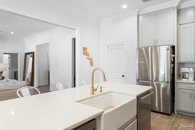 kitchen with light hardwood / wood-style flooring, gray cabinetry, stainless steel appliances, ornamental molding, and sink