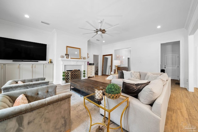 living room featuring light hardwood / wood-style floors, crown molding, and ceiling fan