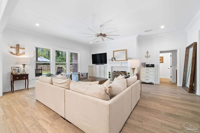 living room featuring ceiling fan, ornamental molding, and light hardwood / wood-style flooring